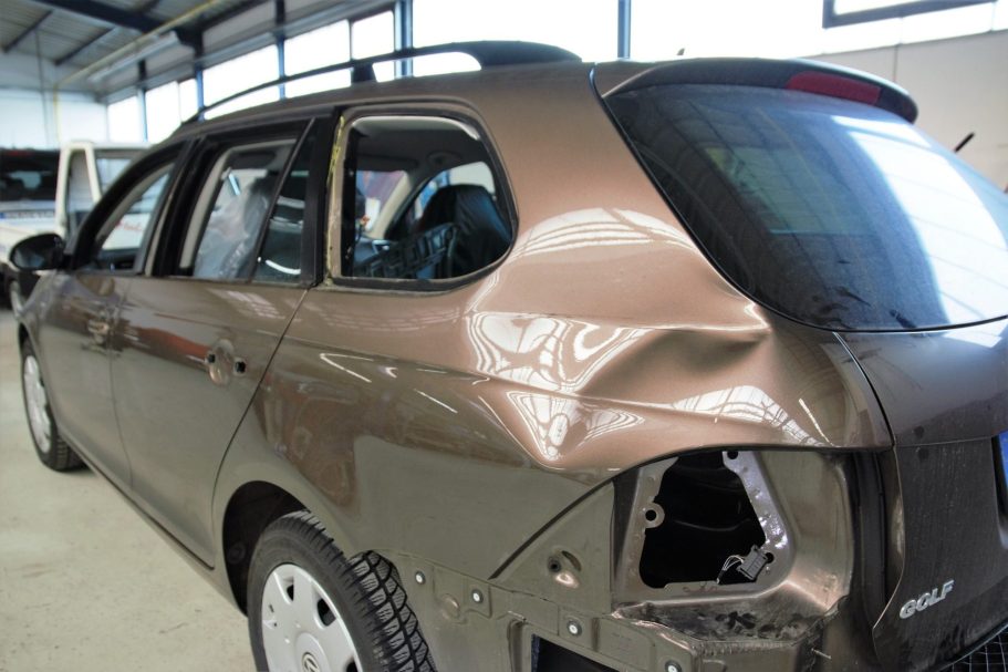Ein beschädigter brauner Kombi mit einer 40 cm. großen Dellen in der hinteren linken Seitenwand und demontierten Rücklicht.